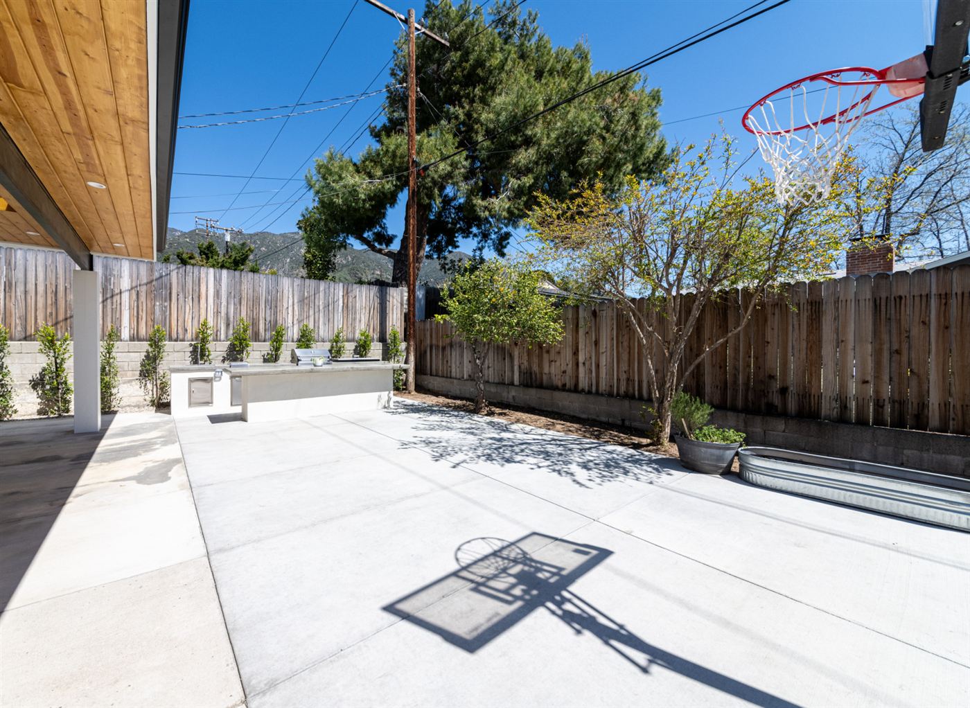Backyard outdoor kitchen with grey countertop and stainless appliances